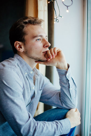 CLOSE-UP OF MAN WITH CAMERA ON WINDOW IN OFFICE