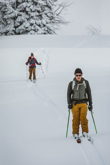 Skiers head downhill while skinning in the wyoming winter backcountry
