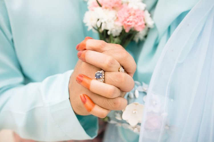 Close-up of bridegroom holding hands