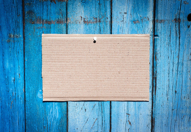 Close-up of blank cardboard on blue wood