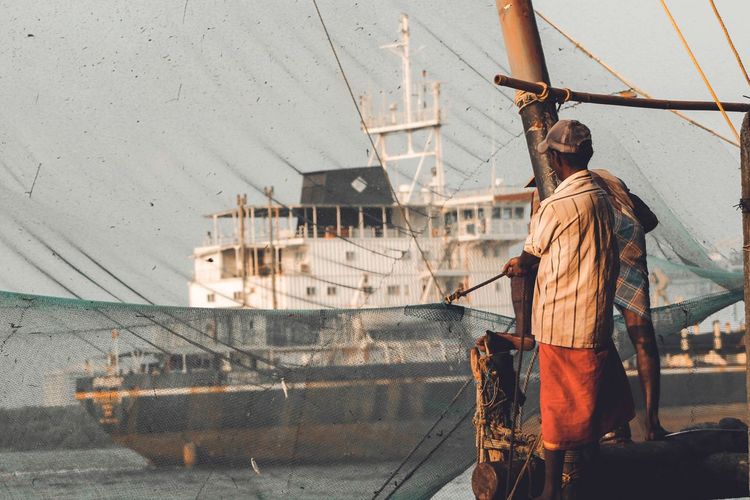 Men standing on boat in sea