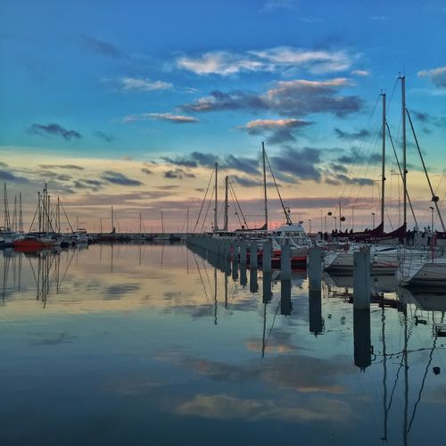 Sailboats in sea at sunset