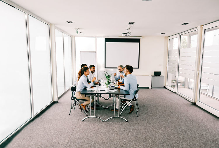 Business people discussing while sitting in board room