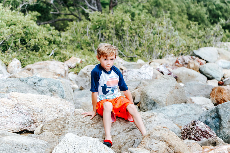 Boy sitting on rock
