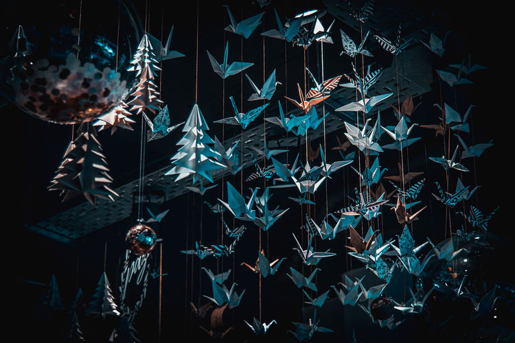 LOW ANGLE VIEW OF ILLUMINATED LIGHTING EQUIPMENT AGAINST BLACK BACKGROUND