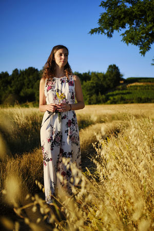 Full length of woman standing on field against sky