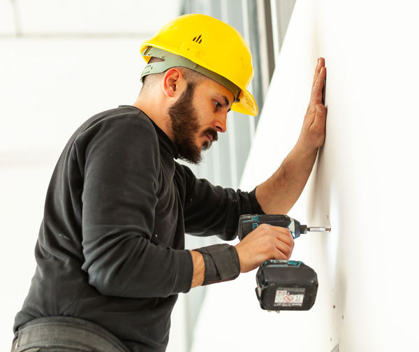 Man working against wall