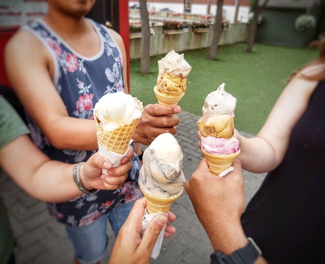 High angle view of friends holding ice cream cones