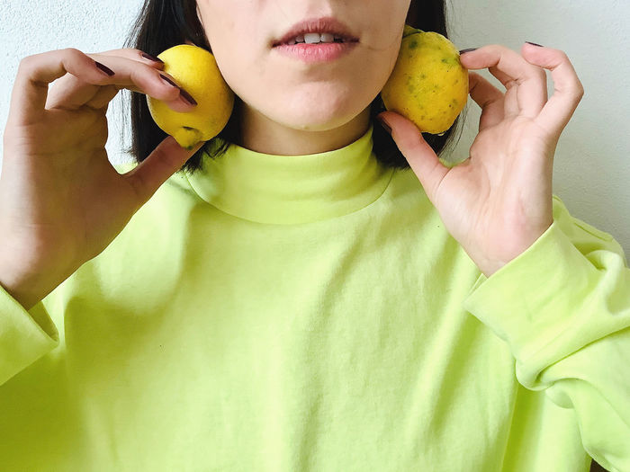 Midsection of woman eating fruit