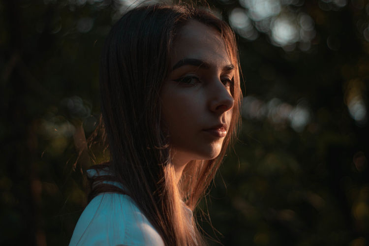 Close-up portrait of young woman at sunset