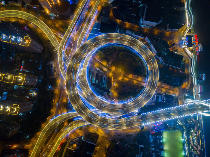 Aerial view of light trails on elevated road in city at night