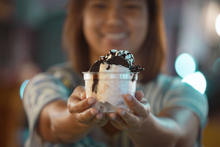 Portrait of woman giving ice cream