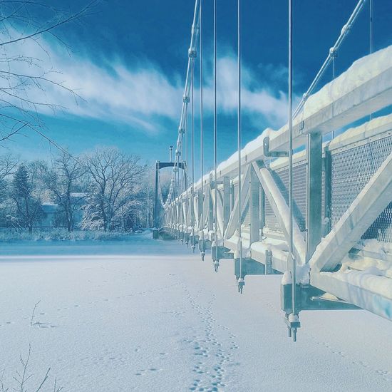 Cropped bridge on snow covered landscape