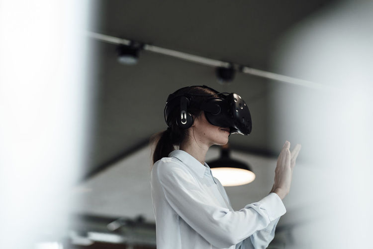 Businesswoman with virtual reality simulator at office