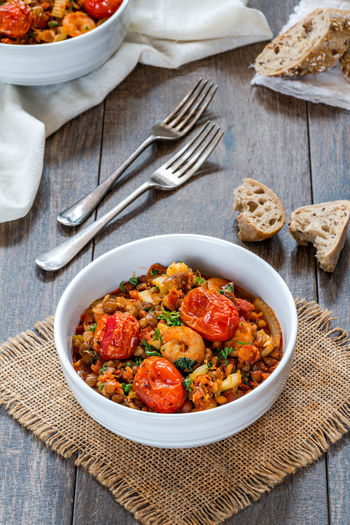Chorizo, lentil and prawn stew with roasted tomatoes - high angle view