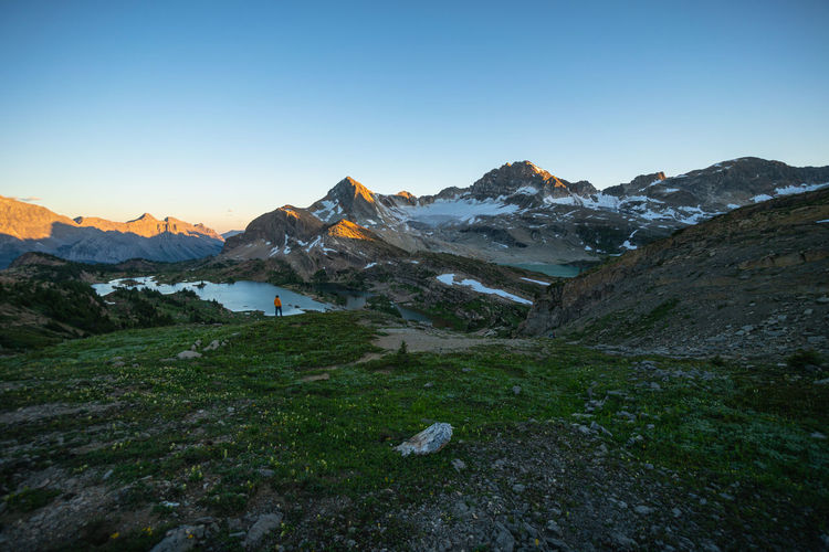 Hiker watching sunrise at limestone lakes height of the rockies
