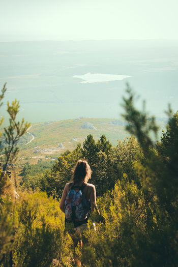 Rear view of woman hiking and looking at view