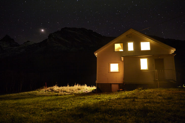 House on field against sky at night
