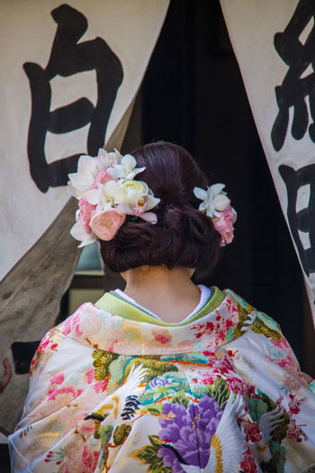 Rear view of woman with pink flower