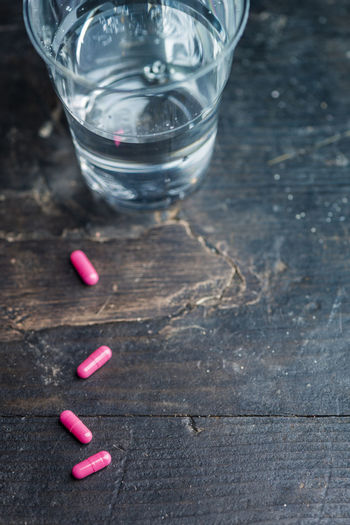 Close-up of water and pills on table