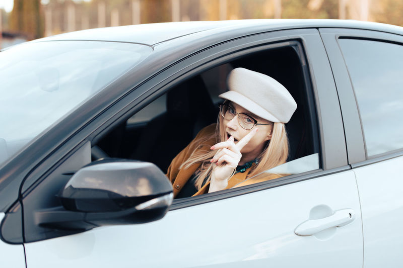 Portrait of young woman sitting in car