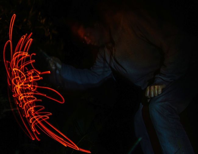Midsection of woman with light painting at night