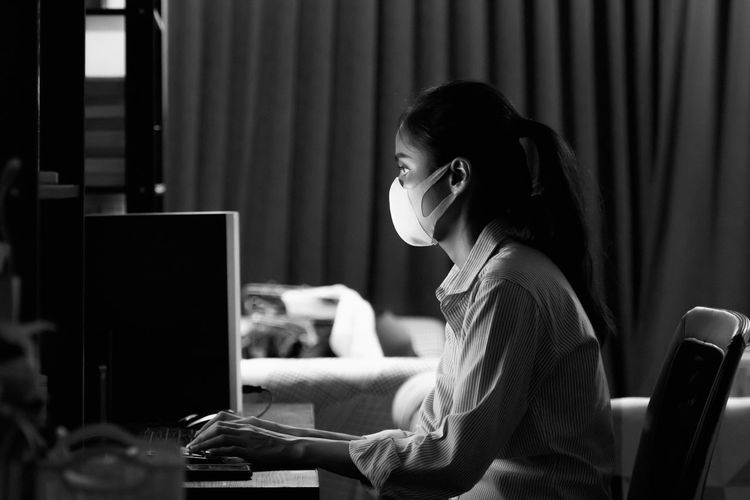 Side view of woman using computer
