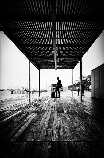 Rear view of man walking on wooden floor