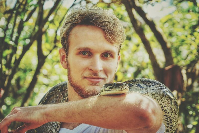 Portrait of young man with snake