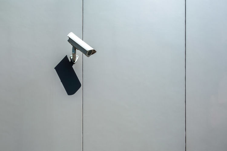 Security camera mounted on a wall of an industrial building with copy space