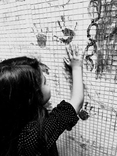 Side view of girl hand printing on wall