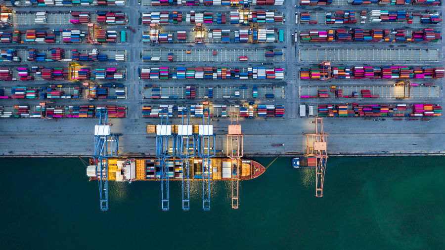 Aerial view container ship loaded in container terminal at night, global business import export