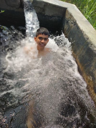 Portrait of smiling boy splashing water