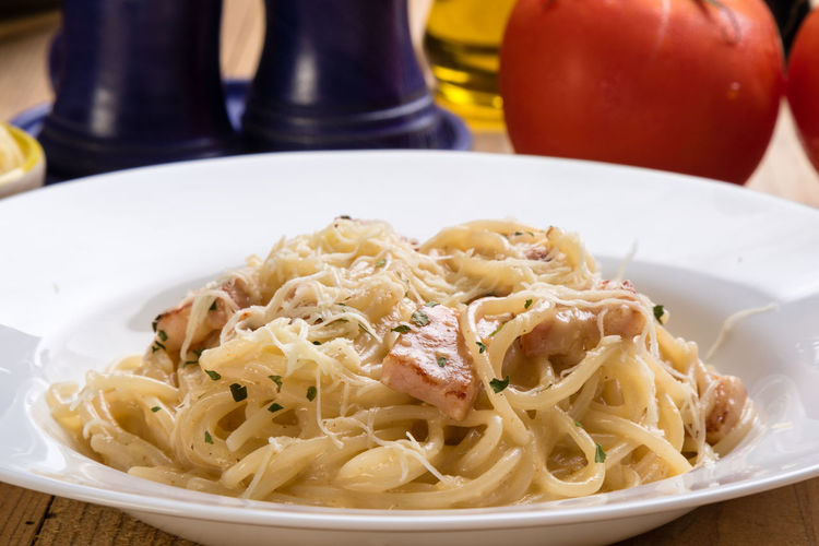 Close-up of spaghetti with carbonara in plate on table