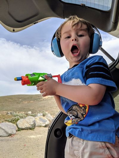 Portrait of boy holding squirt gun in car