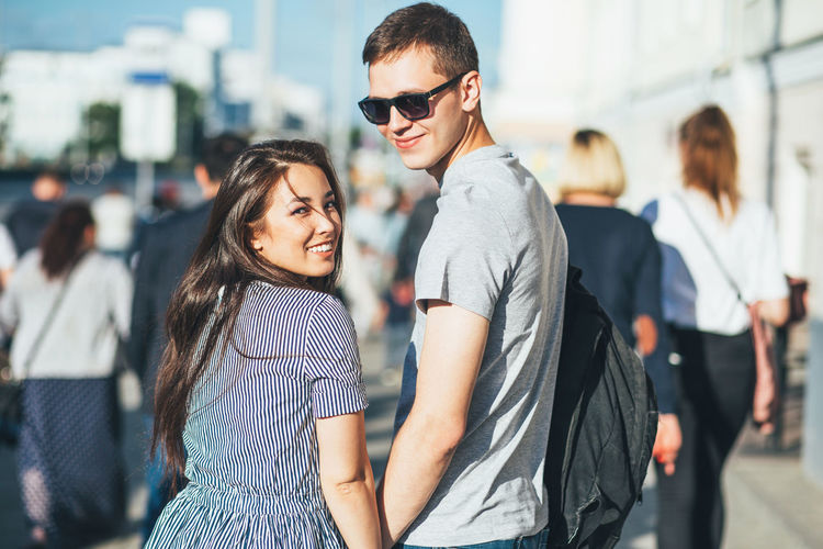Portrait of smiling young couple standing on sunny day