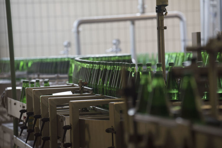 Bottling of mineral water in green bottles, in an industrial plant