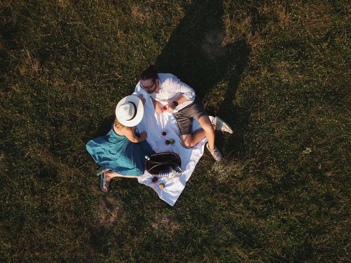 High angle view of couple sitting on picnic blanket