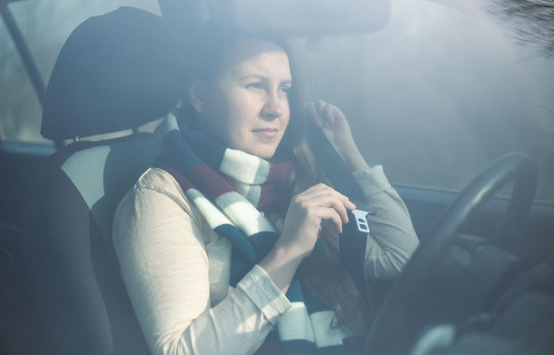 Midsection of woman sitting in car