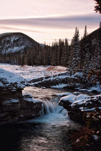 Scenic view of river stream and waterfall during winter