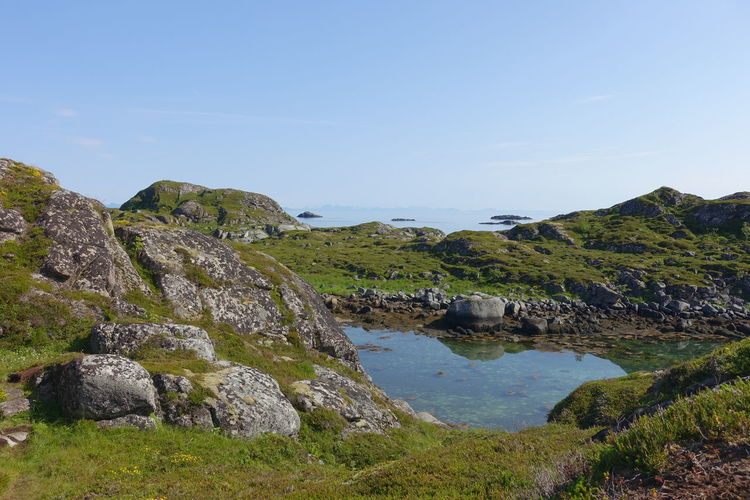 Scenic view of rocks by lake against sky