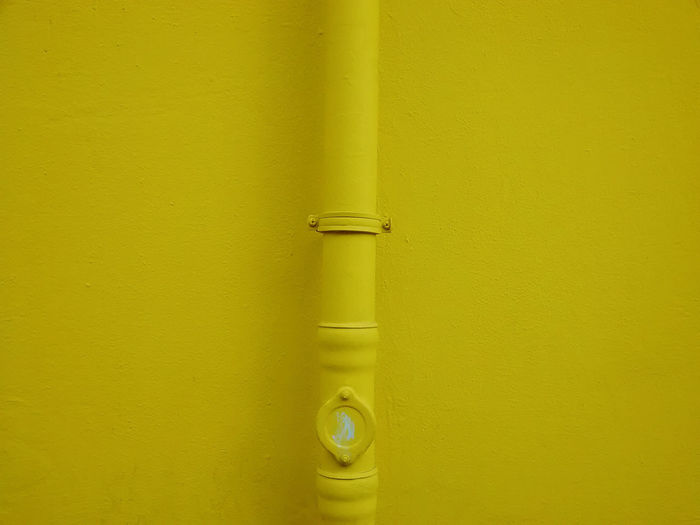 Close-up of pipe on yellow wall