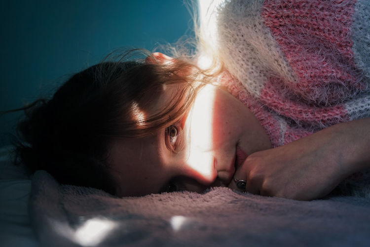 CLOSE-UP PORTRAIT OF CUTE GIRL LYING DOWN ON FLOOR