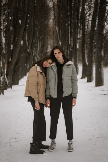 Full length of young women standing on snow covered land