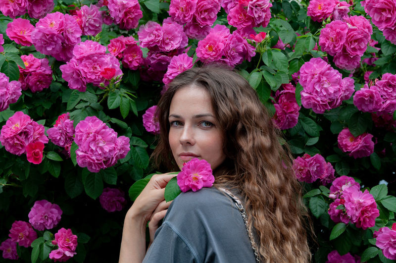 Portrait of young woman with pink roses