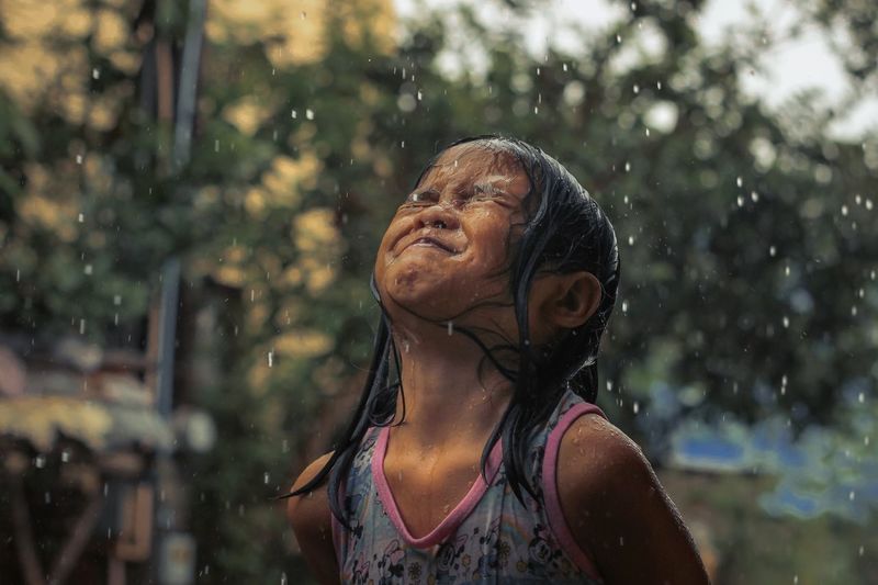 Close-up of girl standing by fountain outdoors