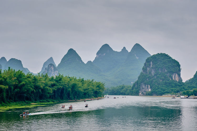 Tourist boats on li river with carst mountains in the background