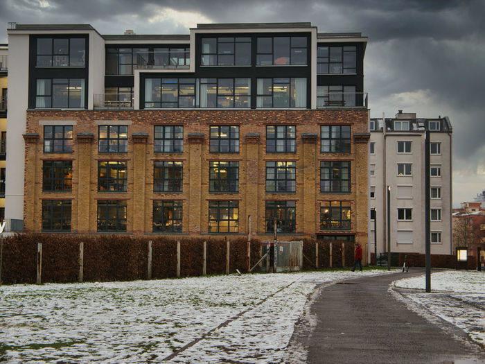 Building by road in city against sky