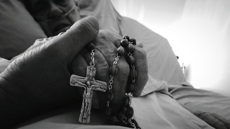 Close-up of hands holding rosary