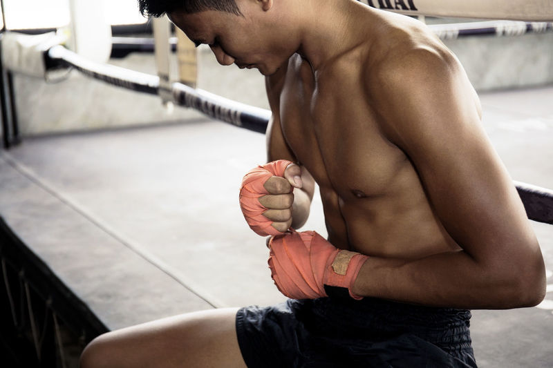 Boxers are using hand wraps in the muay thai training stadium.
